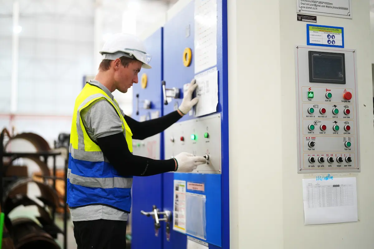 Industrial electrician performing commissioning and system verification on electrical control panel